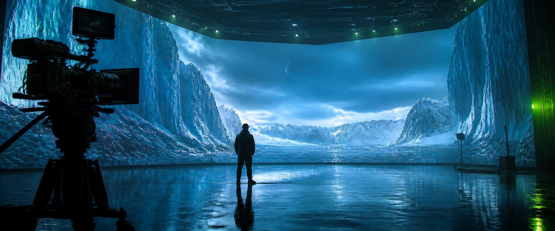 Director and cinema camera on an LED volume stage displaying an icy landscape